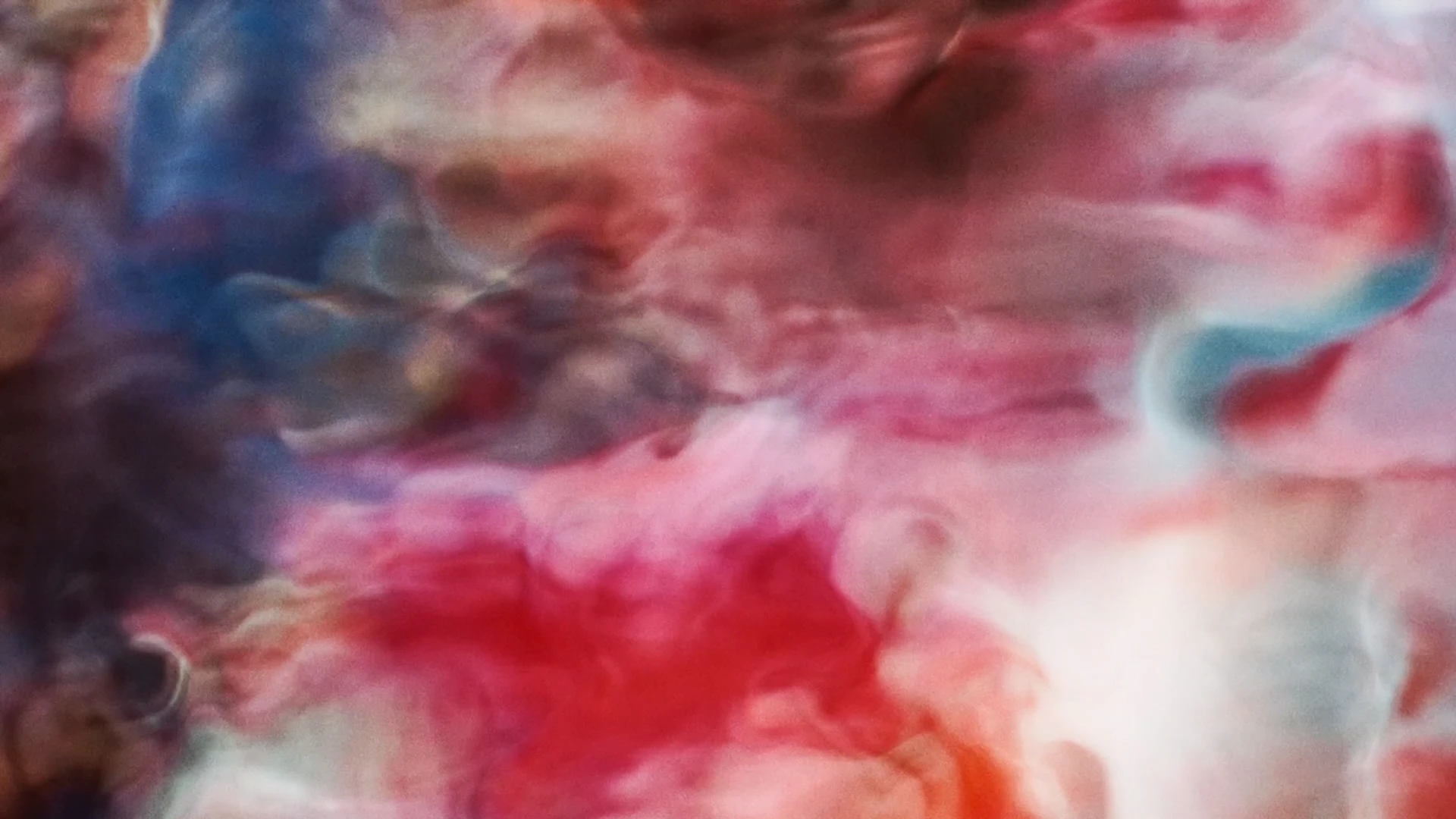 Des volutes de couleurs rouges se mêlent à des teintes bleues dans un étirement de l'image, photogramme de la vidéo I (corpi) traversanti, Les (corps) traversants (2026).